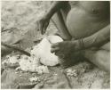 Close-up of Oukwane's hands scraping a water root (print is a cropped image)