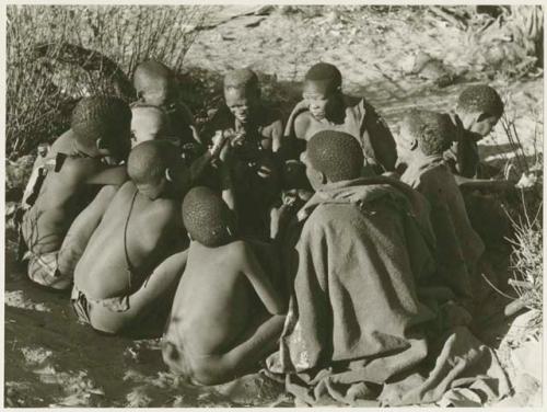 Oukwane's group eating meat, sitting in a cluster (print is a cropped image)