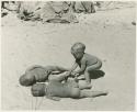 Three boys playing, rolling in the sand (print is a cropped image)