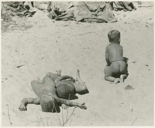 Three boys playing, rolling in the sand (print is a cropped image)