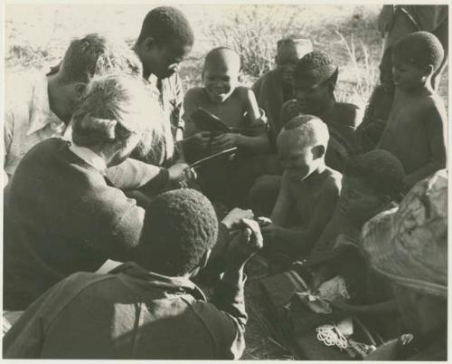 Expedition members giving out presents to Oukwane's group (print is a cropped image)