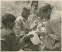 William Donnellan bandaging "/Qui Hunter's" leg with ≠Toma's assistance (print is a cropped image)