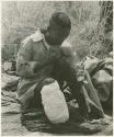 "/Qui Hunter" seated with his foot bandaged (print is a cropped image)