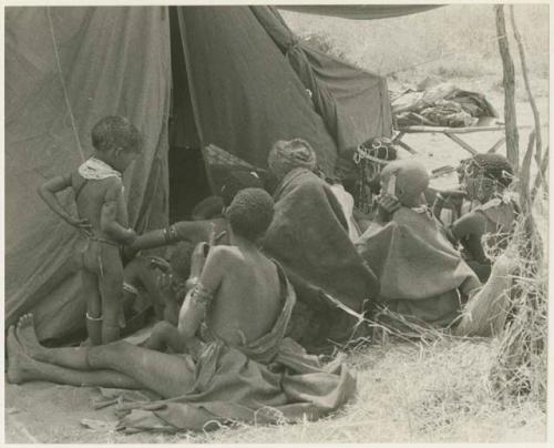 Women waiting outside a tent in which expedition members are dressing /Naoka (/Qui's second wife) and her daughter, /Khoa (print is a cropped image)