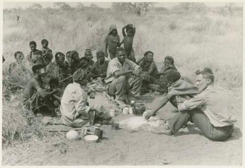 Group of people gathering around "/Qui Hunter" with Kernel Ledimo, John Marshall, and ≠Toma present (print is a cropped image)