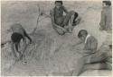 Children likely constructing a playhouse in the sand with sticks, "/Qui Navel" and ≠Toma watching (print is a cropped image)