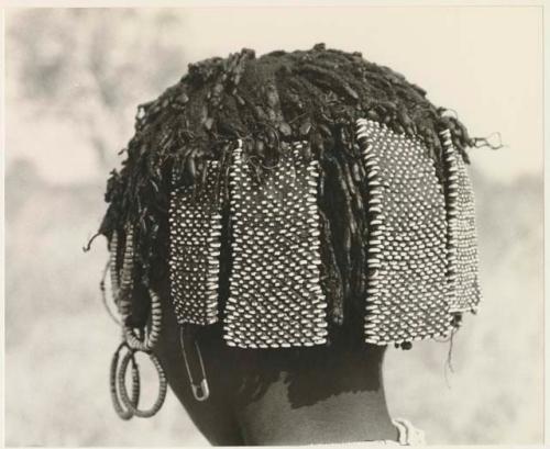 Back of N!ai's head showing beads and other hair accessories (print is a cropped image)