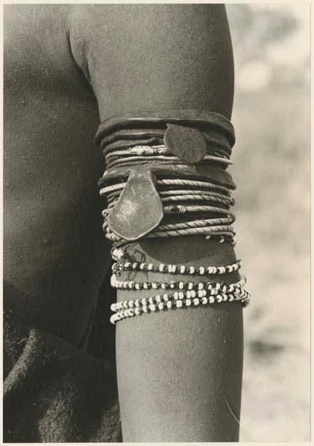 Person's arm wearing upper arm bracelets worn by Ju/’hoan women