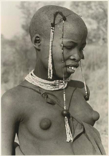 Portrait of a visiting girl with her head shaved, showing ostrich eggshell bead necklace (print is a cropped image)