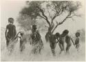 Children standing in grass, including three boys dancing (print is a cropped image)