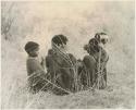 Group of children sitting in grass (print is a cropped image)