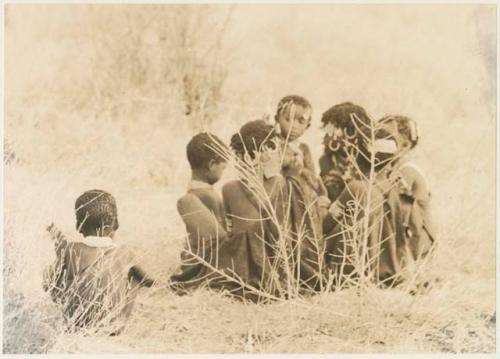 Group of children sitting in grass (print is a cropped image)