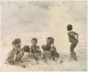 Girls clapping and singing in a circle and a boy dancing (print is a cropped image)