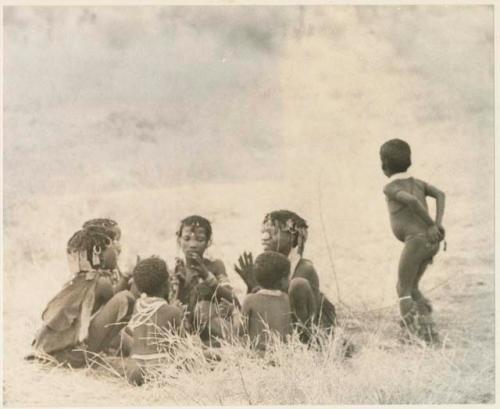 Girls clapping and singing in a circle and a boy dancing (print is a cropped image)