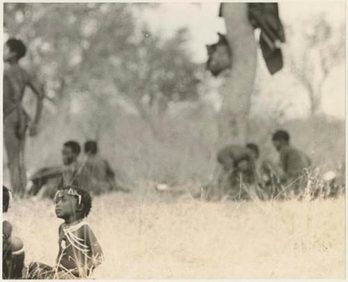 Groups of children sitting in the grass (print is a cropped image)