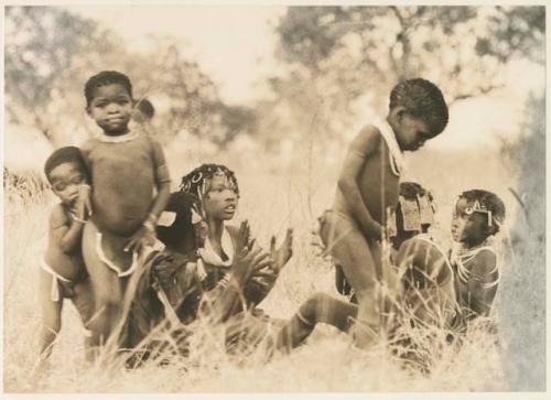 Girls clapping and singing and a boy dancing (print is a cropped image)