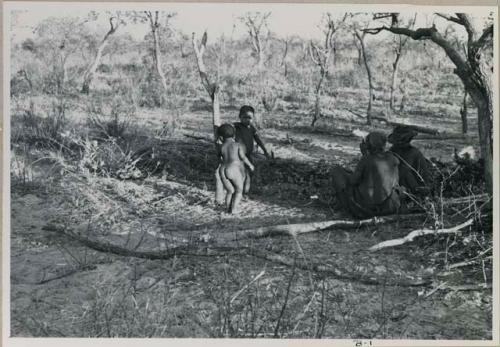 /Ti!kay, a woman, and two children under a tree



