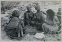 Group of women sitting and playing the dandiri

