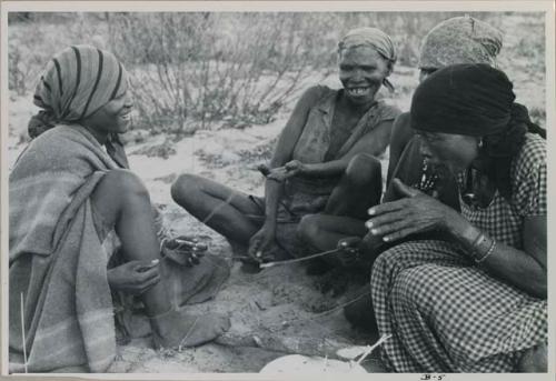 Group of women sitting and playing the dandiri
