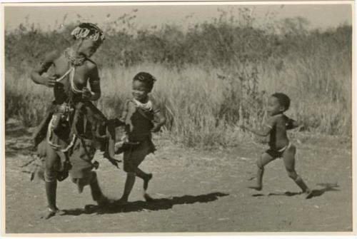 "Women's Ball Game": Khuan//a running, with children running after her (print is a cropped image). tamah n!o’an (ball game)