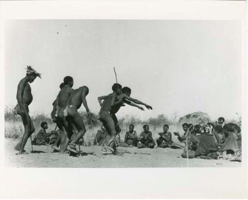 "Daytime Dance at Gautscha 1952, Early in the Dance, approach": Men dancing through a circle of women sitting, with one man's arms outstretched (print is a cropped image)