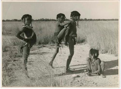 "The 1957-8 Games": Girls playing the "piggy-back" game at the pan, including ≠Gisa (daughter of ≠Gao and Khwo//o-/Gasa), "Little !Nai" and ≠Nisa (print is a cropped image)