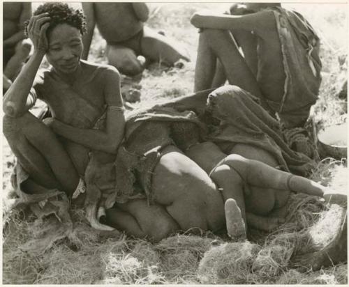 "The 1955 study of groups with children": /Naoka sitting, with a group of children under a kaross beside her (print is a cropped image)