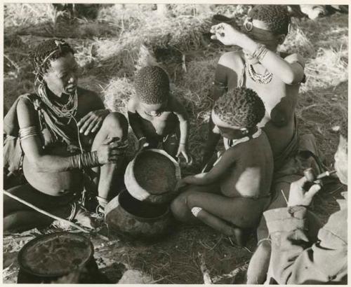 "The 1955 study of groups with children": Di!ai, !U and ≠Toma sitting, and Norna and Debe playing with a broken bowl (print is a cropped image)