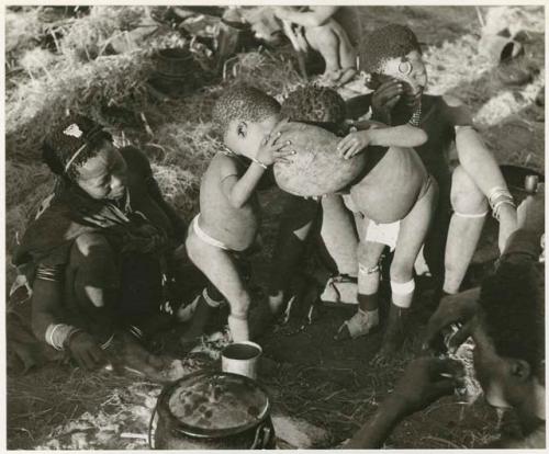 "The 1955 study of groups with children": Di!ai, !U and ≠Toma sitting, and Norna and Debe playing with a broken bowl (print is a cropped image)