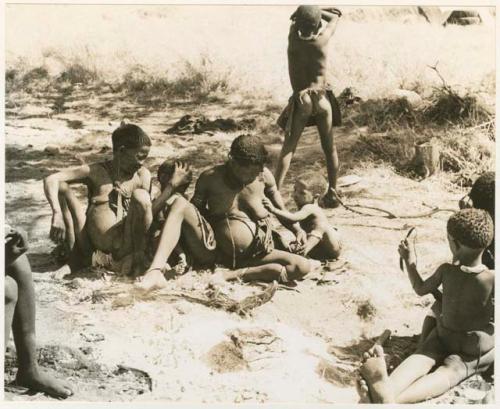 "The 1955 study of groups with children": /Naoka (Di!ai's mother), Di!ai with her two sons, Debe and /Gaishay, seated close together, and !Ungka Norna sitting on !U's lap to the extreme right (print is a cropped image)