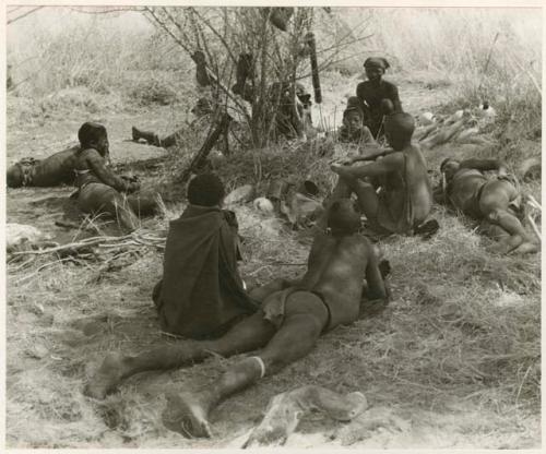 "The 1955 study of groups with children": Group of men and boys lying and sitting in the shade (print is a cropped image)