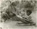 "The 1955 study of groups with children": Di!ai and her child playing a //guashi (print is a cropped image)