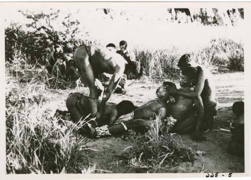 "Children": Row of men in trance being treated by other men