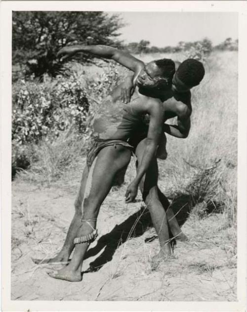 "Children": Medicine man falling backwards into the arms of another man (print is a cropped image)