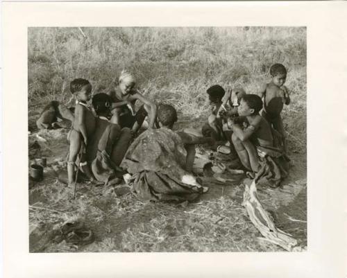 "Photos of Children": Left to right: !Ungka Norna leaning against her mother, !U, "Gao Lame" wearing a headscarf, /Naoka (wife of "Gao Medicine"), //Khuga (/Naoka and "Gao Medicine's" daughter) and behind: an unidentified, visiting girl, !U's mother, and Bau, standing (print is a cropped image)