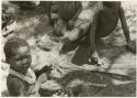 "Little ≠Gao" pushing a handmade toy automobile made from veldkos and other unidentified children (print is a cropped image)