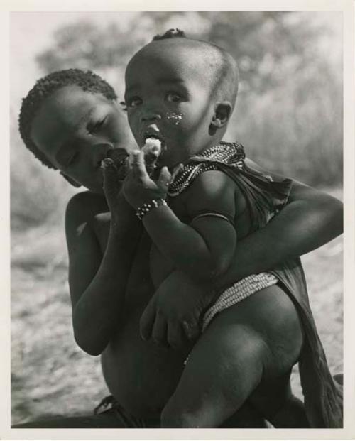 "Norna with groups": /Gaishay (son of ≠Toma) feeding mealies to his sister, !Ungka Norna (print is a cropped image)