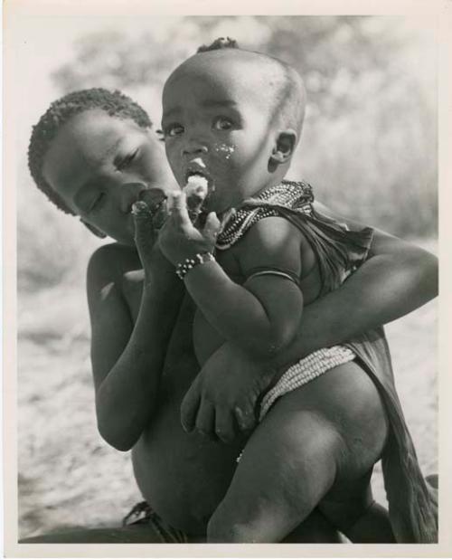 "Norna with groups": /Gaishay (son of ≠Toma) feeding mealies to his sister, !Ungka Norna (print is a cropped image)