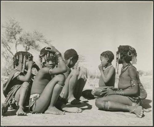 "Norna with groups": Girl playing a //guashi, sitting with a group of girls and boys (print is a cropped image)