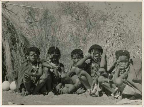 "Norna with groups": Five girls sitting in a row beside N!ai's wedding skerm, including N!ai, ≠Gisa (daughter of ≠Gao and Khwo//o-/Gasa), Nama (daughter of "Geo Helmet" of Band 2) and ≠Nisa (wife of "/Gao Music" in Band 1) (print is a cropped image)