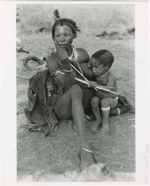 Di!ai nursing Debe who clutches a toy bow and arrow (print is a cropped image)