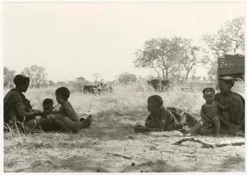 Khuan//a sitting to the left with her sons, ≠Toma and /Qui, "Old /Gasa" lying down, and an unidentified woman and girl sitting to the right (print is a cropped image)