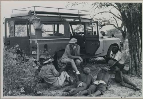 Nicholas England and a group of people sitting by the Land Rover



