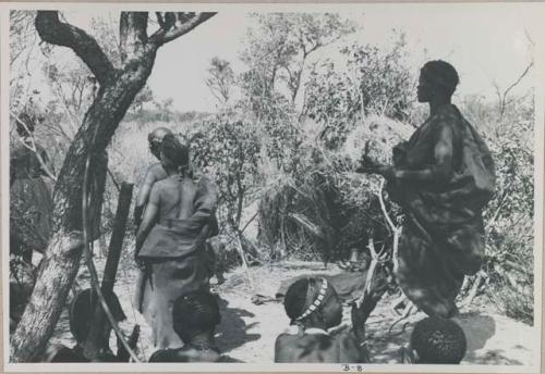 [No folder title]: Three women standing and four women sitting, performing a menstruation ceremony
