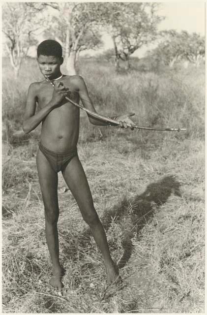 !Naishi (brother of /Goishay) playing a musical bow, full figure standing (print is a cropped image; image is flipped)