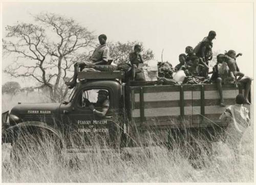 Truck loaded with a group of Ju/'hoansi on top, with Heinrich Neumann behind the wheel (print is a cropped image)