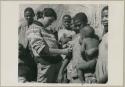 Woman holding a baby and having her skin color documented by Deborah Marshall (print is a cropped image)