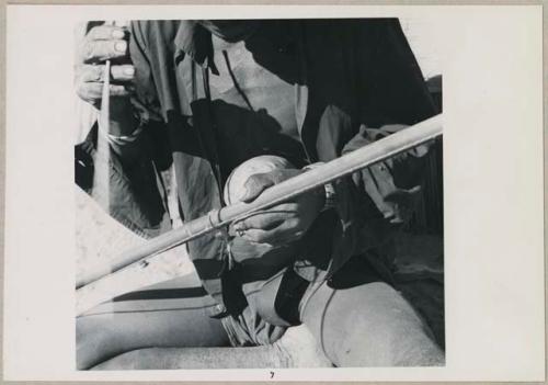 Kafuro playing the hunting bow, braced, with calabash, close-up of playing technique (print is a cropped image)