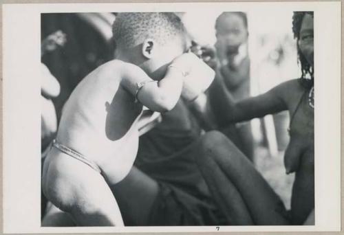 Tãõ (Daou or !Aikwe), wife of Tango (Chitango), and a baby drinking from a cup (print is a cropped image)