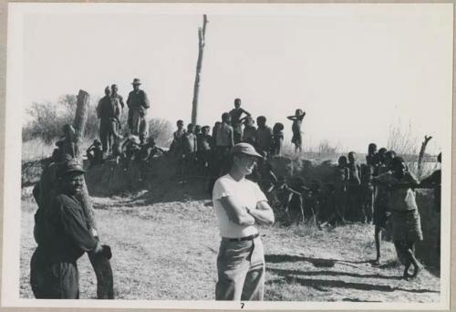 Group of people standing and watching float, including Nicholas England (print is a cropped image)